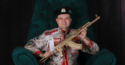 An immortal dictator holding a golden AK-47M.