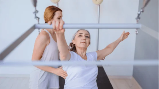 An elderly woman practicing pilates