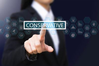 A businessperson presses the word 'conservative'