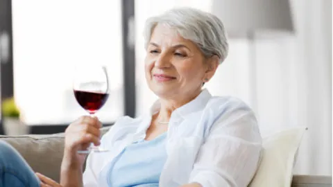 Elderly woman drinking alcohol